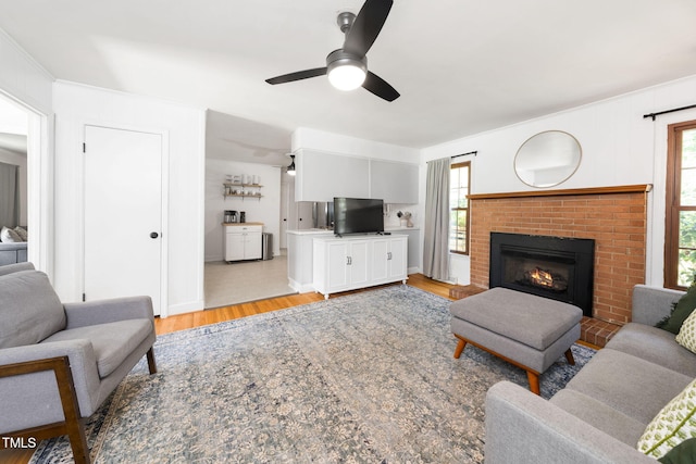 5203 Shady Bluff St, Durham, NC 27704 - living area featuring light wood-type flooring, a ceiling fan, a fireplace, and crown molding