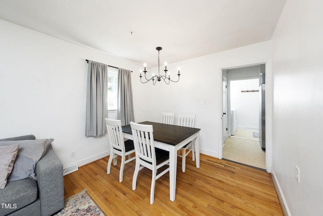 5203 Shady Bluff St, Durham, NC 27704 - dining room featuring a chandelier, light wood-style floors, and washer / dryer