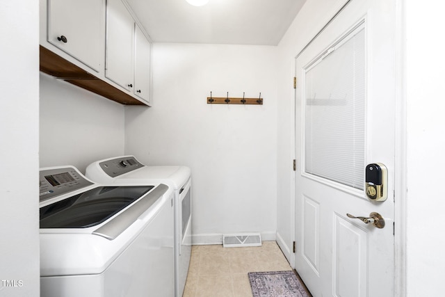 5203 Shady Bluff St, Durham, NC 27704 - laundry area featuring washing machine and dryer, cabinet space, and light tile patterned floors