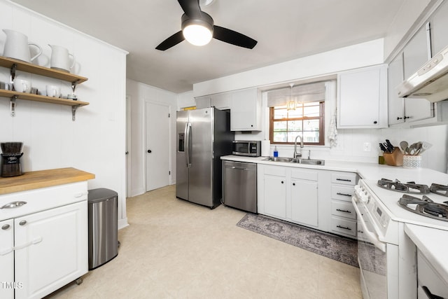 5203 Shady Bluff St, Durham, NC 27704 - kitchen with stainless steel appliances, a ceiling fan, wall chimney exhaust hood, and white cabinetry