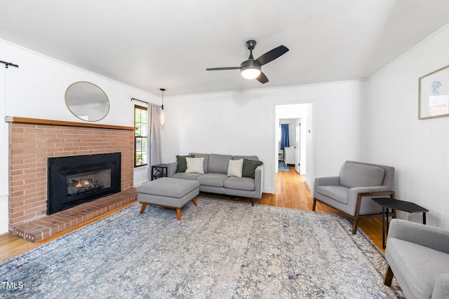 5203 Shady Bluff St, Durham, NC 27704 - living area with wood finished floors, ceiling fan, a brick fireplace, and crown molding
