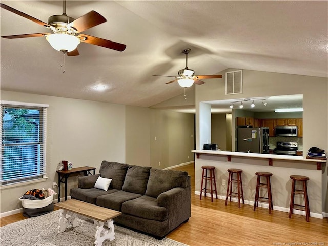 6622 Vaughn Rd, Fayetteville, NC 28304 - living room with ceiling fan, light wood finished floors, vaulted ceiling, and a textured ceiling