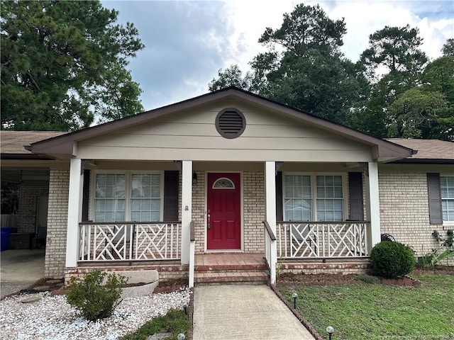 6622 Vaughn Rd, Fayetteville, NC 28304 - view of front of house featuring brick siding, covered porch, a carport, and driveway