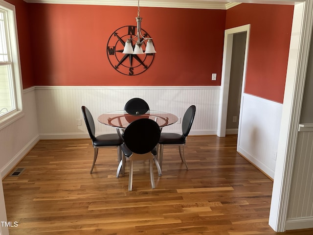1034 Snapdragon Dr, Wake Forest, NC 27587 - dining area with a chandelier, a wainscoted wall, and wood finished floors