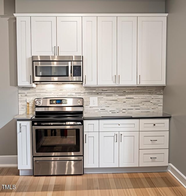 90 Miry Creek Ln, Clinton, NC 28328 - kitchen featuring stainless steel appliances, dark countertops, decorative backsplash, and white cabinets