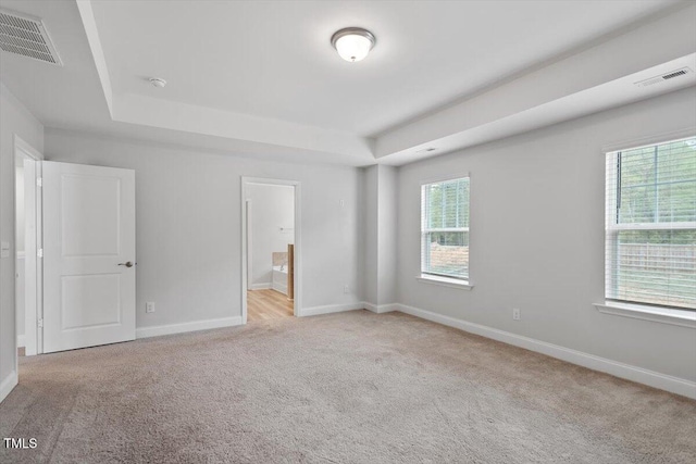 815 Harmony Ranch Ln, Franklinton, NC 27525 - unfurnished bedroom featuring a raised ceiling, light carpet, and ensuite bath