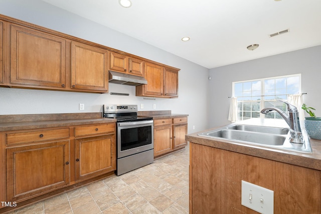 2486 Ingleside Dr, High Point, NC 27265 - kitchen with stainless steel electric range oven, under cabinet range hood, brown cabinetry, recessed lighting, and stone finish flooring
