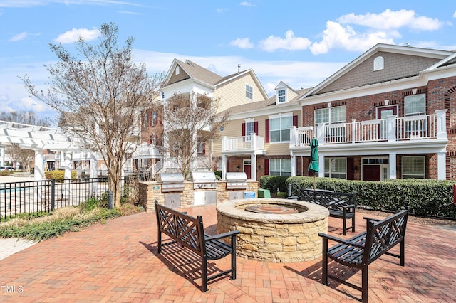 10210 Sablewood Dr Unit 214, Raleigh, NC 27617 - view of patio / terrace with exterior kitchen, an outdoor fire pit, and a residential view