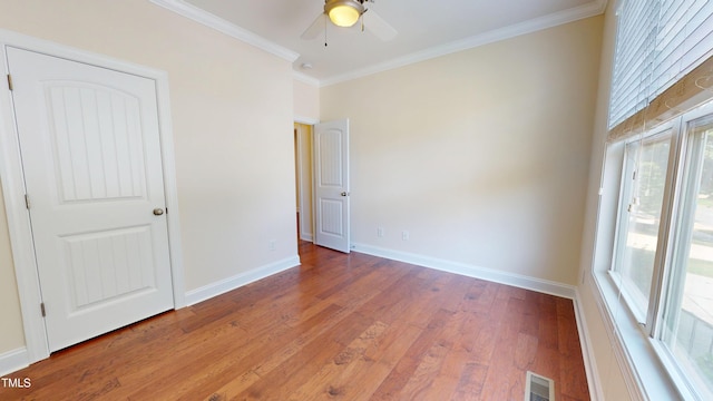 1524 Lily Creek Dr, Cary, NC 27518 - unfurnished bedroom featuring multiple windows, wood finished floors, ornamental molding, and a ceiling fan