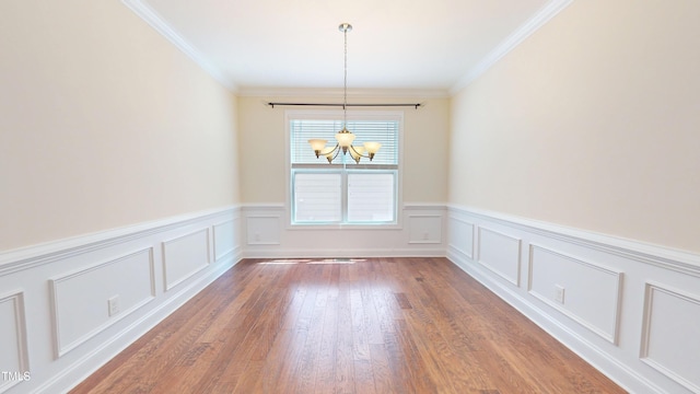 1524 Lily Creek Dr, Cary, NC 27518 - unfurnished dining area with a chandelier, a wainscoted wall, crown molding, wood finished floors, and a decorative wall