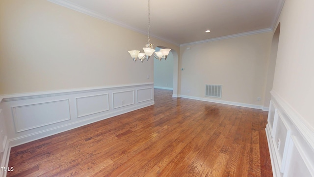 1524 Lily Creek Dr, Cary, NC 27518 - empty room with a chandelier, ornamental molding, wood finished floors, arched walkways, and wainscoting