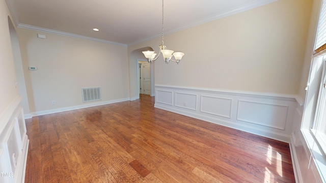 1524 Lily Creek Dr, Cary, NC 27518 - empty room with a chandelier, arched walkways, crown molding, healthy amount of natural light, and wood finished floors