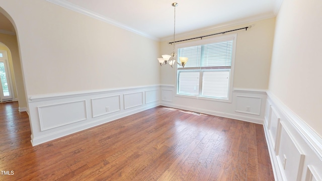1524 Lily Creek Dr, Cary, NC 27518 - unfurnished room featuring arched walkways, a chandelier, wood finished floors, a decorative wall, and a wainscoted wall