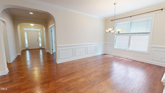 1524 Lily Creek Dr, Cary, NC 27518 - entryway featuring a chandelier, healthy amount of natural light, arched walkways, wood finished floors, and wainscoting