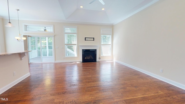 1524 Lily Creek Dr, Cary, NC 27518 - unfurnished living room featuring ceiling fan, wood finished floors, a fireplace with flush hearth, a raised ceiling, and a chandelier