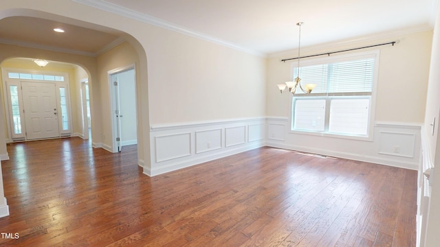 1524 Lily Creek Dr, Cary, NC 27518 - entrance foyer featuring a chandelier, wood finished floors, a wainscoted wall, arched walkways, and crown molding
