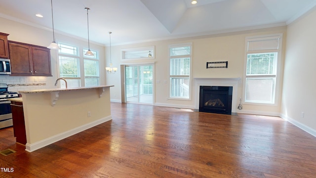 1524 Lily Creek Dr, Cary, NC 27518 - kitchen featuring dark wood finished floors, gas range oven, plenty of natural light, ornamental molding, and recessed lighting