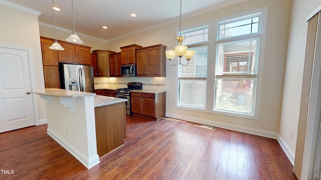 1524 Lily Creek Dr, Cary, NC 27518 - kitchen with stainless steel appliances, backsplash, light stone countertops, dark wood-style flooring, and hanging light fixtures