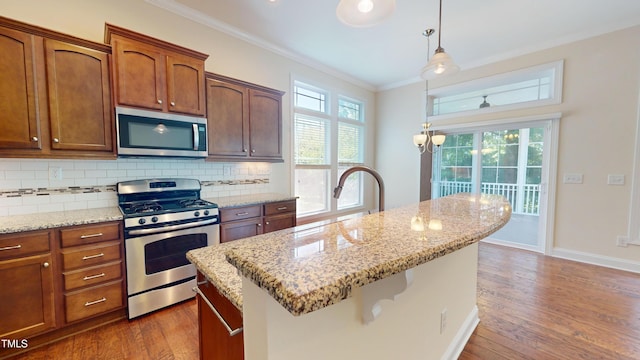 1524 Lily Creek Dr, Cary, NC 27518 - kitchen featuring appliances with stainless steel finishes, dark wood-style flooring, ornamental molding, decorative light fixtures, and plenty of natural light