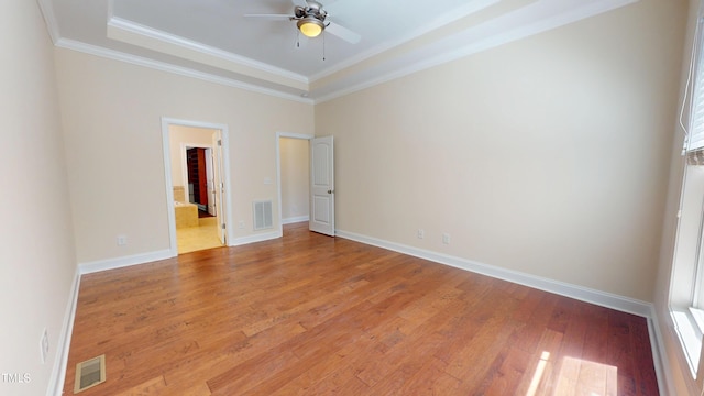 1524 Lily Creek Dr, Cary, NC 27518 - unfurnished bedroom featuring a tray ceiling, light wood-type flooring, crown molding, and multiple windows