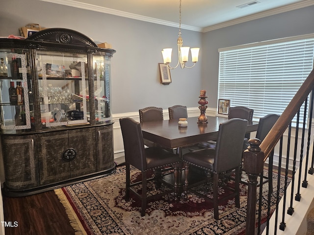 1303 Salters St, Burlington, NC 27215 - dining area with a chandelier, wood finished floors, ornamental molding, plenty of natural light, and a wainscoted wall
