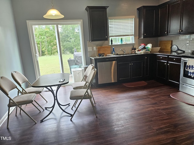 1303 Salters St, Burlington, NC 27215 - kitchen featuring stainless steel appliances, decorative backsplash, dark wood-style floors, dark countertops, and pendant lighting