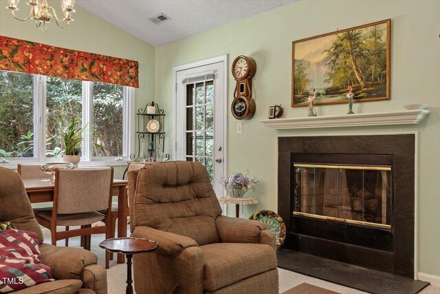 4201 Pin Oak Dr, Durham, NC 27707 - living room featuring lofted ceiling, a chandelier, and a glass covered fireplace