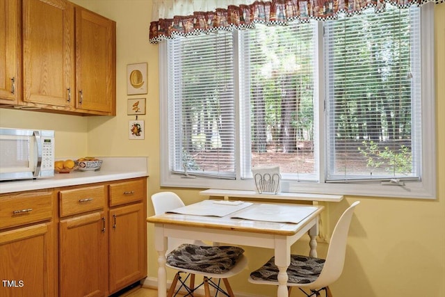 4201 Pin Oak Dr, Durham, NC 27707 - kitchen with white microwave, light countertops, plenty of natural light, and brown cabinets