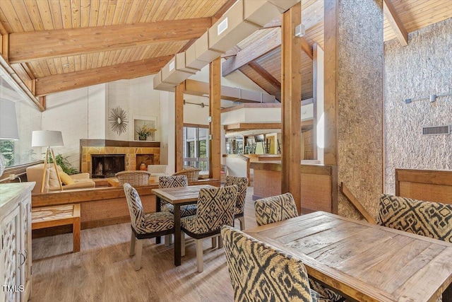 4201 Pin Oak Dr, Durham, NC 27707 - dining space with a wood ceiling with exposed beams, plenty of natural light, wood finished floors, a tile fireplace, and high vaulted ceiling
