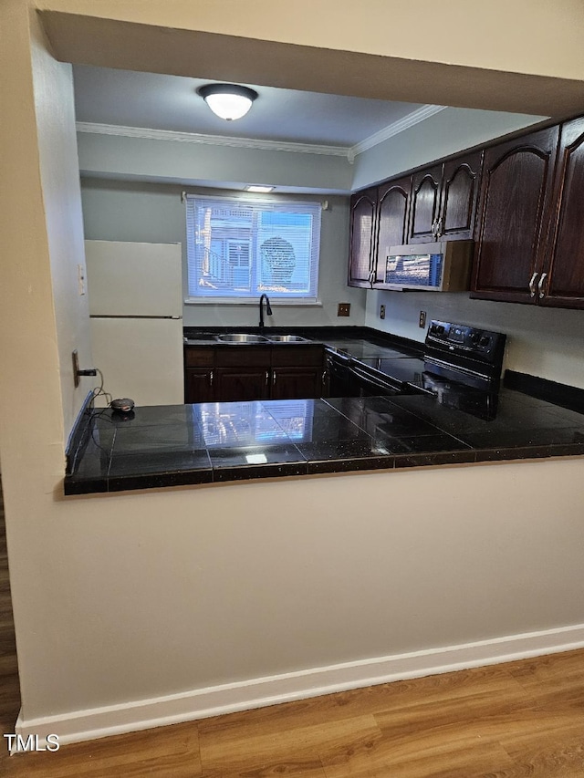 7030 Longstreet Dr Unit A, Raleigh, NC 27615 - kitchen featuring freestanding refrigerator, black / electric stove, crown molding, stainless steel microwave, and dark brown cabinets