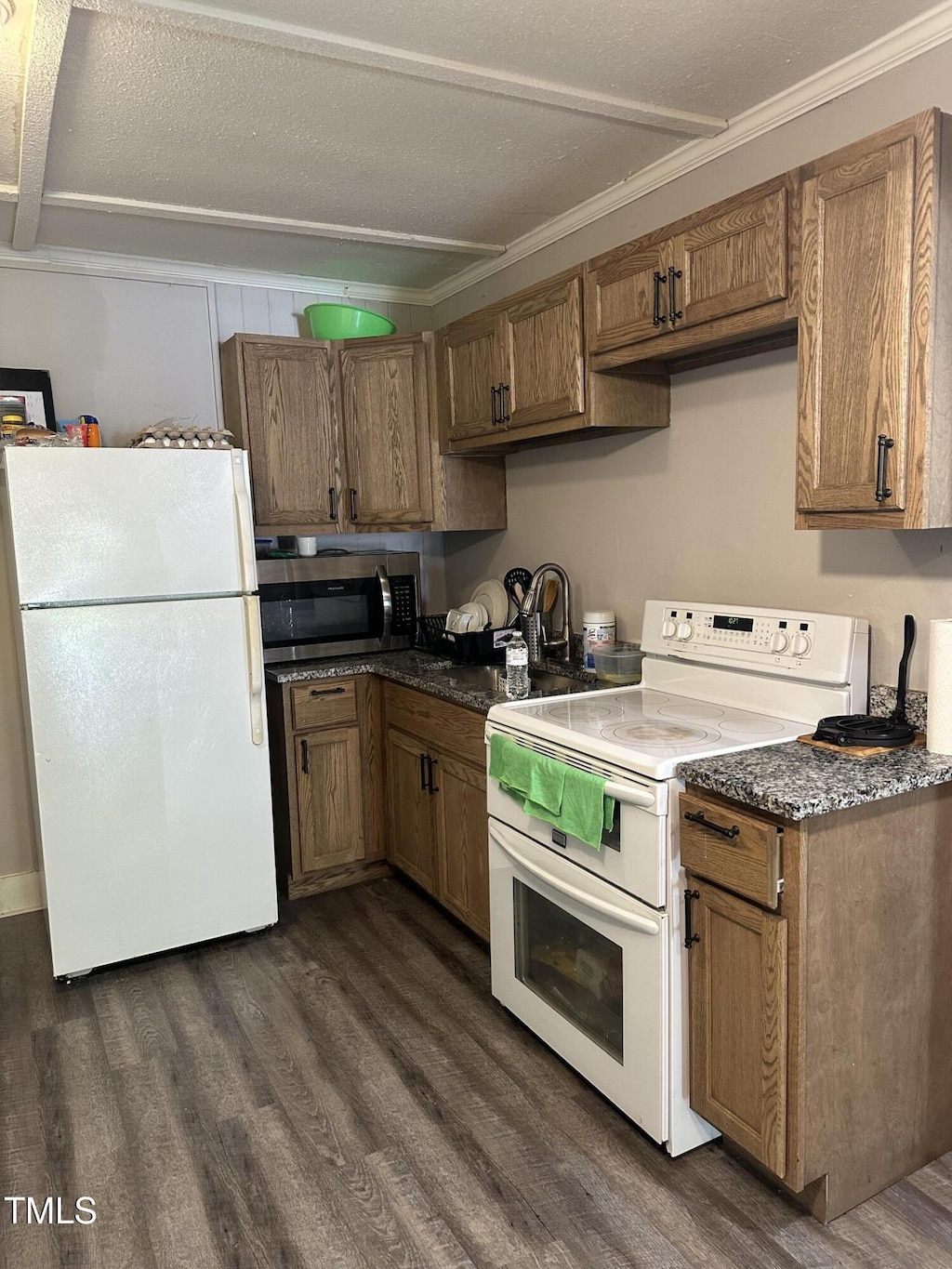 615 Manchester St SE, Wilson, NC 27893 - kitchen with white appliances, dark wood-style floors, brown cabinetry, and ornamental molding