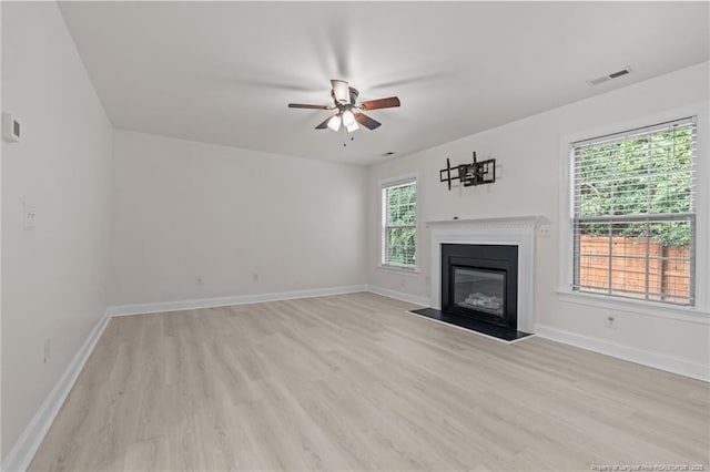 297 Colonist Pl, Cameron, NC 28326 - unfurnished living room featuring light wood finished floors, a ceiling fan, and a glass covered fireplace