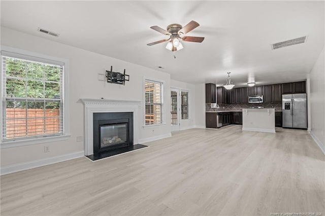297 Colonist Pl, Cameron, NC 28326 - unfurnished living room featuring light wood finished floors, ceiling fan, and a glass covered fireplace