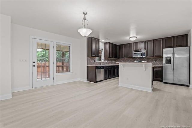 297 Colonist Pl, Cameron, NC 28326 - kitchen featuring stainless steel appliances, light wood-style floors, dark brown cabinetry, decorative backsplash, and light countertops