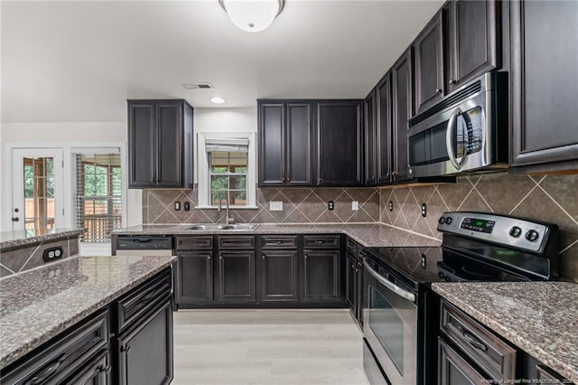 297 Colonist Pl, Cameron, NC 28326 - kitchen with appliances with stainless steel finishes, stone counters, light wood finished floors, backsplash, and recessed lighting