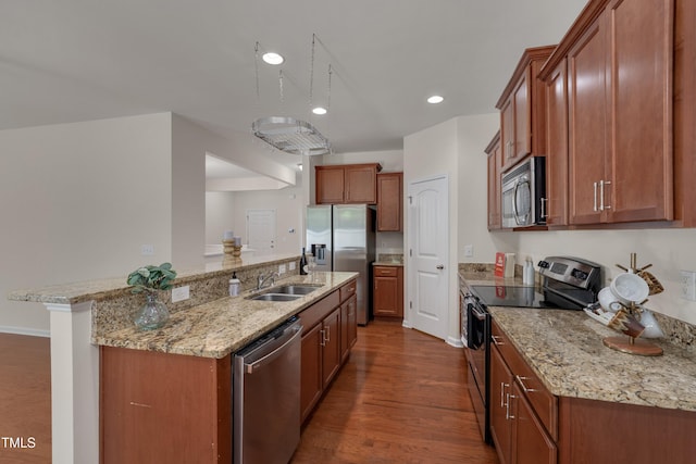 130 Holly Berry Ln, Durham, NC 27703 - kitchen with stainless steel appliances, dark wood-style floors, light stone counters, brown cabinets, and recessed lighting
