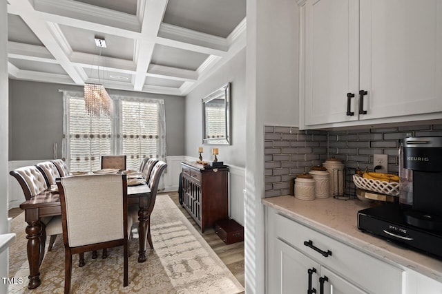 27 Needham Ln, Clayton, NC 27527 - dining area with wainscoting, beam ceiling, coffered ceiling, light wood-type flooring, and a decorative wall