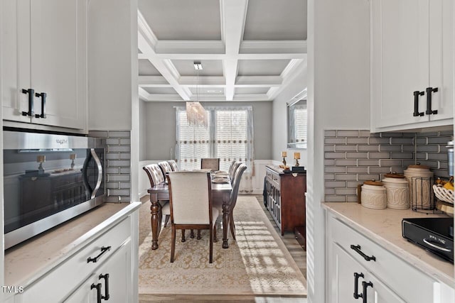 27 Needham Ln, Clayton, NC 27527 - kitchen with stainless steel microwave, coffered ceiling, beam ceiling, white cabinetry, and tasteful backsplash