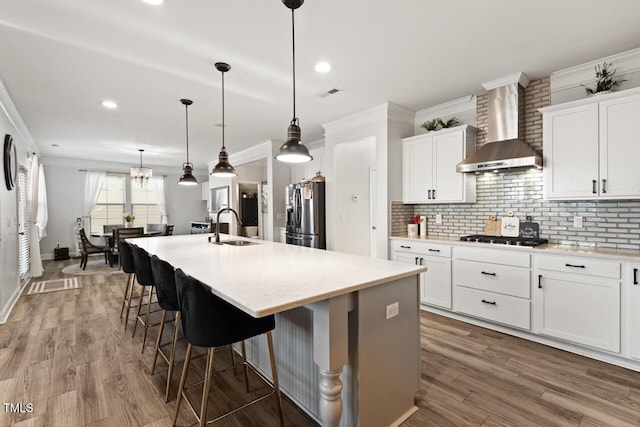 27 Needham Ln, Clayton, NC 27527 - kitchen with wall chimney exhaust hood, stainless steel fridge with ice dispenser, ornamental molding, an island with sink, and backsplash