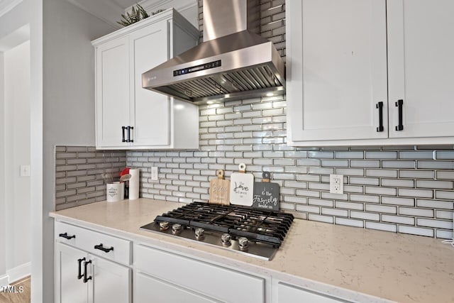 27 Needham Ln, Clayton, NC 27527 - kitchen featuring wall chimney exhaust hood, stainless steel gas cooktop, white cabinets, light stone counters, and decorative backsplash