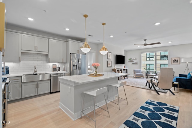 105 Chatham Walk Ln Unit 208, Cary, NC 27511 - kitchen with stainless steel appliances, gray cabinetry, open floor plan, decorative backsplash, and a breakfast bar area