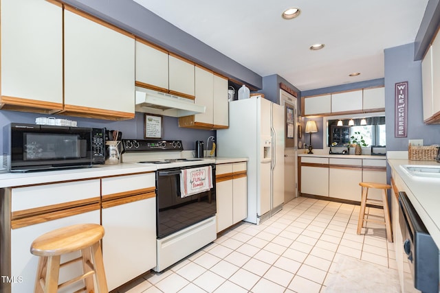 7 Weybridge Pl, Chapel Hill, NC 27517 - kitchen with electric stove, under cabinet range hood, black microwave, light countertops, and recessed lighting