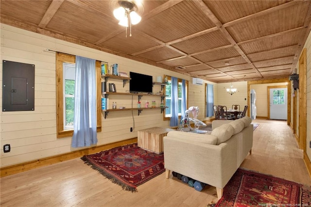 1203 Simpson St, Fayetteville, NC 28305 - living room featuring electric panel, wood finished floors, wood walls, a chandelier, and ceiling fan