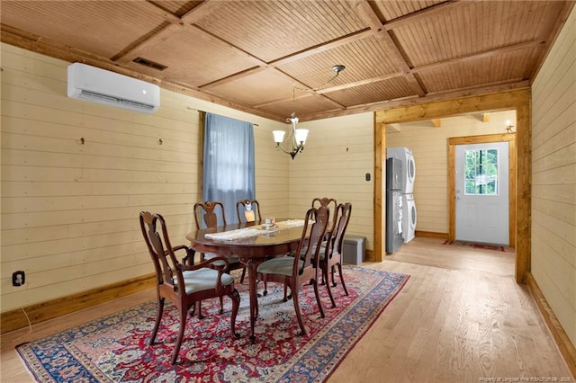 1203 Simpson St, Fayetteville, NC 28305 - dining room with a wall mounted AC, stacked washer / drying machine, wooden walls, a chandelier, and light wood-style flooring