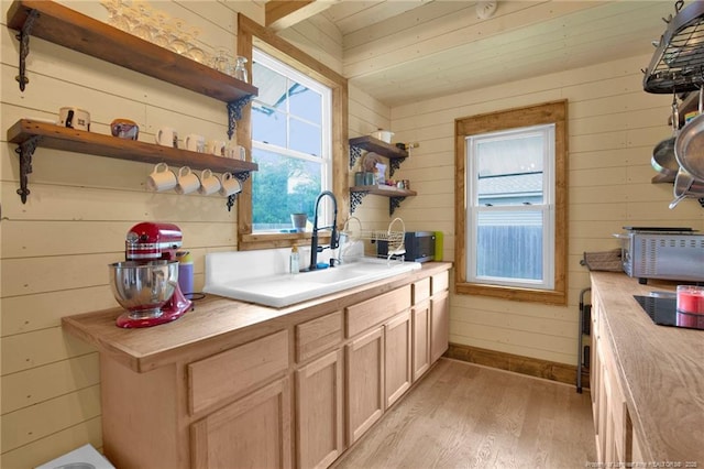1203 Simpson St, Fayetteville, NC 28305 - kitchen with open shelves, light wood-style floors, wooden walls, cooktop, and light brown cabinetry