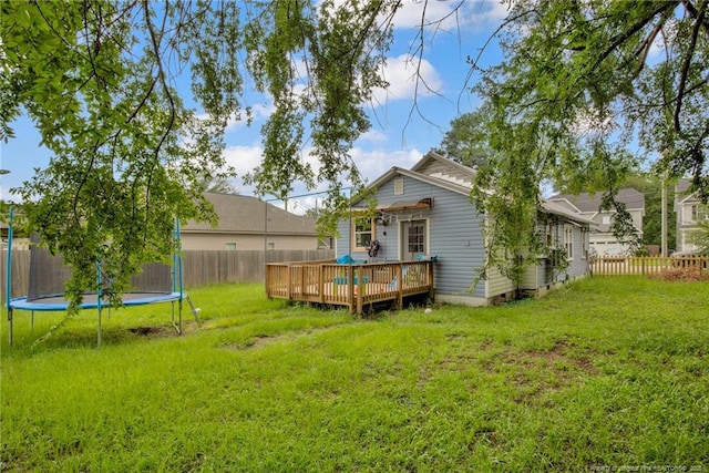 1203 Simpson St, Fayetteville, NC 28305 - rear view of house featuring a trampoline, a wooden deck, and a fenced backyard