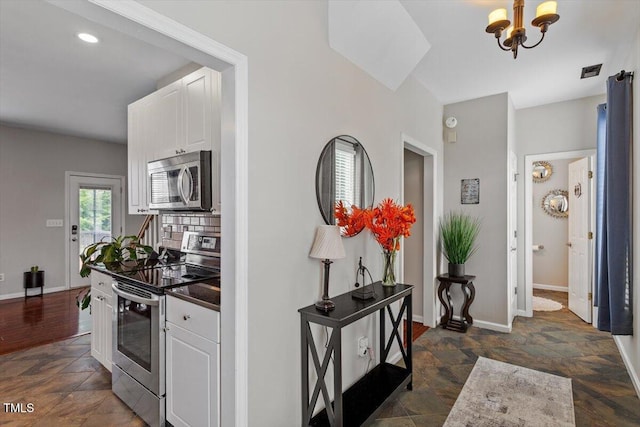 2301 Laurel Valley Way, Raleigh, NC 27604 - kitchen with appliances with stainless steel finishes, white cabinets, a chandelier, and dark stone finish floors