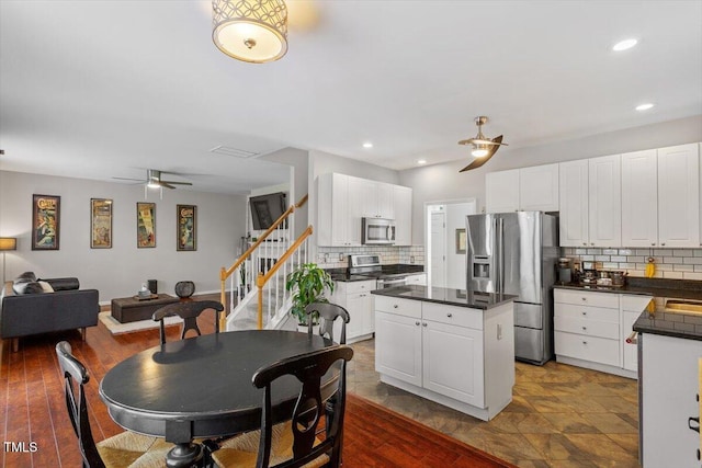 2301 Laurel Valley Way, Raleigh, NC 27604 - kitchen with a ceiling fan, appliances with stainless steel finishes, a kitchen island, tasteful backsplash, and dark countertops