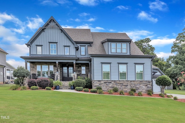 3329 Donlin Dr, Wake Forest, NC 27587 - view of front of property with a front yard, stone siding, covered porch, a shingled roof, and board and batten siding