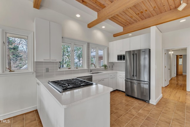 206 Spring Ln, Chapel Hill, NC 27514 - kitchen featuring stainless steel appliances, healthy amount of natural light, a peninsula, light countertops, and a wooden ceiling with exposed beams